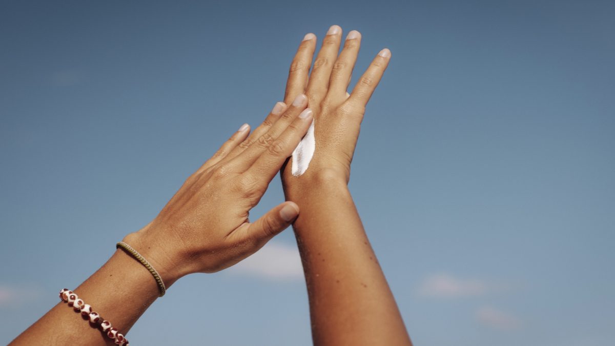 Applying Sun Cream Under Clear Blue Sky