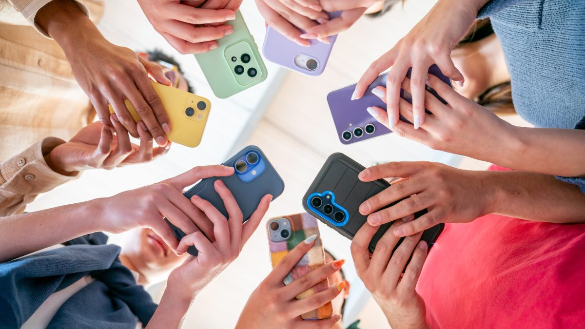 Group of friends in a circle holding their phones